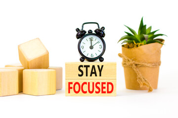 Stay focused symbol. Concept words Stay focused on wooden blocks on a beautiful white background. Black alarm clock. Business, support, motivation, psychological stay focused concept. Copy space
