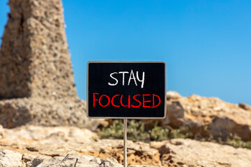Stay focused symbol. Concept words Stay focused on beautiful black chalk blackboard on a beautiful beach stone background. Business, support, motivation, psychological stay focused concept. Copy space