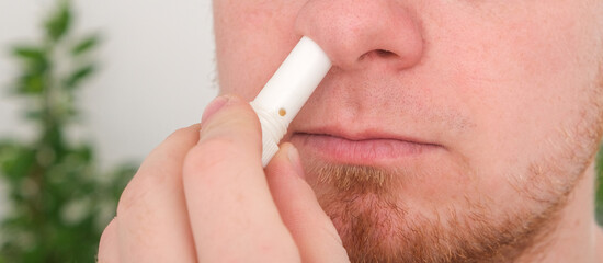 Adult man uses nasal stick inhaler to smell for relieve dizzy and faint symptoms. Concept health problem, sickness and remedy. Increases freshness, reduces dizziness and stuffy nose. self take care.