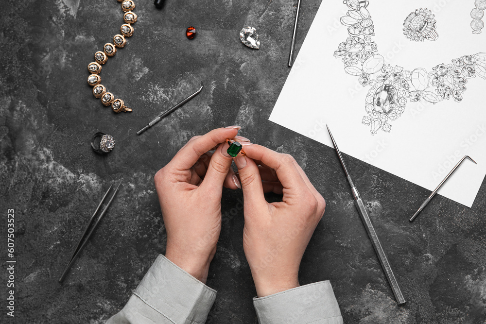 Female jeweler with ring on dark table, closeup