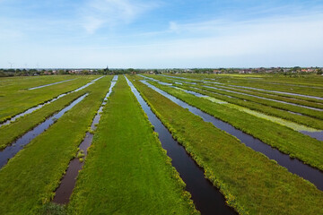 Wall Mural - Stunning aerial view of the wide open Dutch polder landscape with parallel water filled ditches and canals