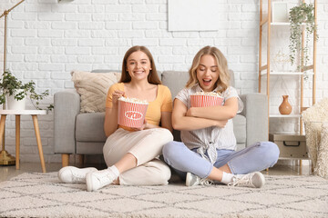 Wall Mural - Young sisters eating popcorn at home