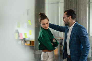 Mature man abusing his younger colleague, concept of harassment at workplace.