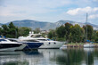 Luxury modern yachts in marina with a beautiful view of the mountains and reflection in calm water. Vacation and tourism concept 
