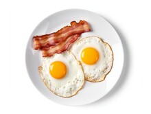 Fried Eggs And Bacon Breakfast Isolated On White Background. Top View