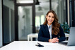 © bnenin - Portrait of a pretty businesswoman working on a laptop at the office.