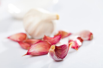 Wall Mural - Garlic cloves over white background. Fresh unpeeled garlic.