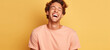 Young adult man laughing agaisnt solid color background.  Image generative AI.