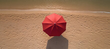 Red Beach Umbrella, Aerial Tranquility.  Red Beach Umbrella Atop A Pristine Sandy Beach, People-Free, And Magnificently Top View.  Generative AI.  