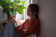 © DimaBerlin - Sad depressed teen adolescent girl looking side hold phone sit on floor at home. Upset teenager with cellphone waiting for call feel bad anxious need help. Cyberbullying, difficult relations at school