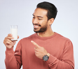 Poster - Man pointing at milk, drink and health with nutrition, calcium and vitamins with vanilla shake isolated on studio background. Male person with smile, promote dairy product in glass and healthy life