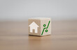 © GamePixel - Property Taxes And Real Estate Market Growth concept. House, property investment ideas about real estate companies. Hand holding house icon on wooden block with percent and rise of arrow.
