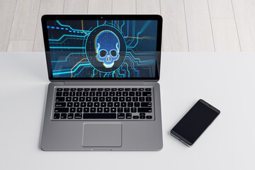 Close up of laptop with blue circuit skull hologram on screen and cellphone on white desktop. Cyber attack and malware concept. 3D Rendering.