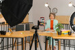 © Westend61 - Businesswoman recording online class sitting at table in studio