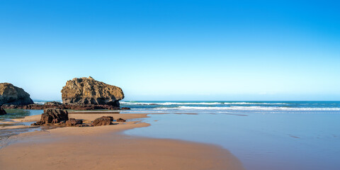 Canvas Print - beach with rock on a sunny blue sky day