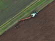 © AmazingAerialAgency - Aerial view of a tractor ploughing at a farm in Brandenburg, Germany.