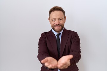 Poster - Middle age business man with beard wearing suit and tie smiling with hands palms together receiving or giving gesture. hold and protection