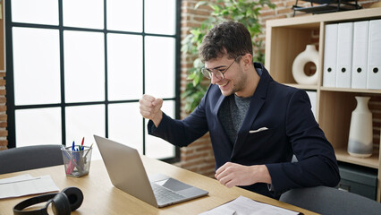 Poster - Young hispanic man business worker using laptop celebrating at office