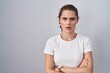 © Krakenimages.com - Beautiful brunette woman standing over isolated background skeptic and nervous, disapproving expression on face with crossed arms. negative person.