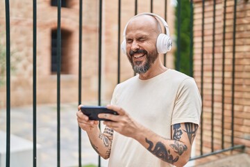 Sticker - Young bald man smiling confident watching video on smartphone at street