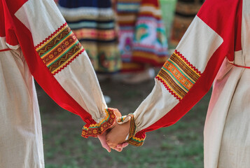 Russian folk traditions. Folk festivals. Children in beautiful Russian traditional outfits hold hands and lead a round dance in Tsaritsyno Park. National Russian clothes. Sundresses and kokoshniks.