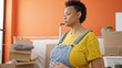 Young pregnant woman touching belly with relaxed expression at new home