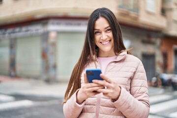 Sticker - Young woman smiling confident using smartphone at street