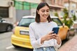 © Krakenimages.com - Young hispanic woman smiling confident using smartphone at street