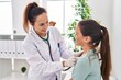 © Krakenimages.com - Woman and girl doctor and patient auscultating chest at clinic