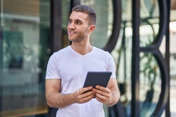 Canvas Print - Young caucasian man smiling confident using touchpad at street