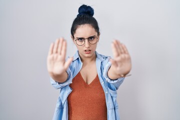 Sticker - Young modern girl with blue hair standing over white background doing stop gesture with hands palms, angry and frustration expression