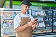 © Krakenimages.com - Young hispanic man waiter smiling confident using smartphone at coffee shop terrace