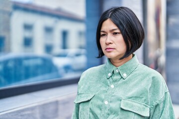 Sticker - Young chinese woman with relaxed expression standing at street