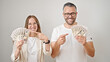 © Krakenimages.com - Young woman and man smiling confident pointing to dollars over isolated white background