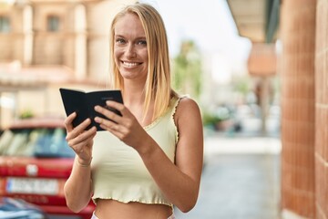 Sticker - Young blonde woman smiling confident reading canada passport at street