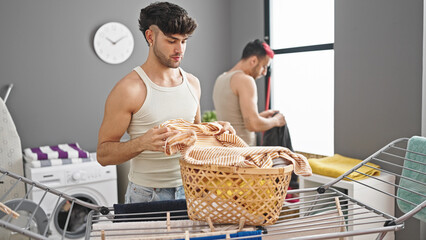 Sticker - Two men couple hanging clothes on clothesline at laundry room