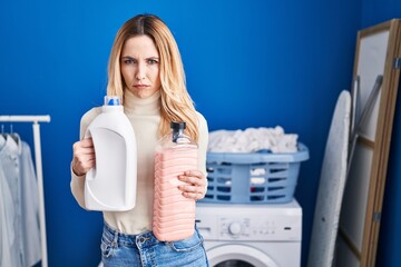 Sticker - Young caucasian doctor woman holding detergent bottle at laundry room skeptic and nervous, frowning upset because of problem. negative person.