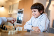 © Olena Shvets - Little adorable smiling boy playing chess at home