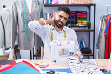 Poster - Young arab man tailor stressed using sewing machine at tailor shop