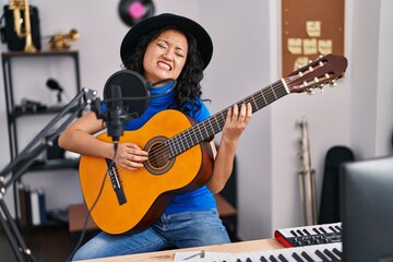 Sticker - Young chinese woman artist singing song playing guitar at music studio