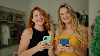 Sticker - Two women smiling confident using smartphones at clothing store