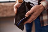 Fototapeta  - Young man showing empty wallet at office