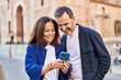 © Krakenimages.com - Middle age man and woman couple using smartphone standing together at street