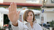© Krakenimages.com - Middle age hispanic woman doing stop gesture with hand at street