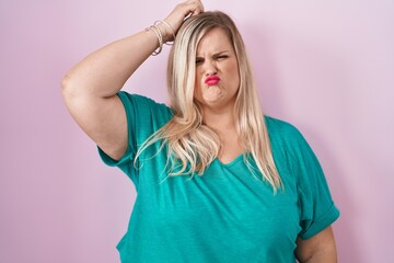 Poster - Caucasian plus size woman standing over pink background confuse and wondering about question. uncertain with doubt, thinking with hand on head. pensive concept.