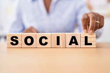 Black woman holding cubes with social word on the table