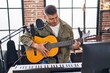 © Krakenimages.com - Young hispanic man musician singing song playing classical guitar at music studio