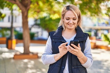 Canvas Print - Young blonde woman smiling confident using smartphone at park