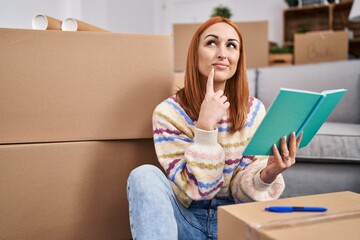 Sticker - Young caucasian woman reading book with doubt expression at new home