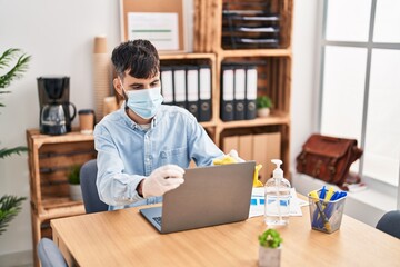 Poster - Young hispanic man business worker cleaning laptop at office